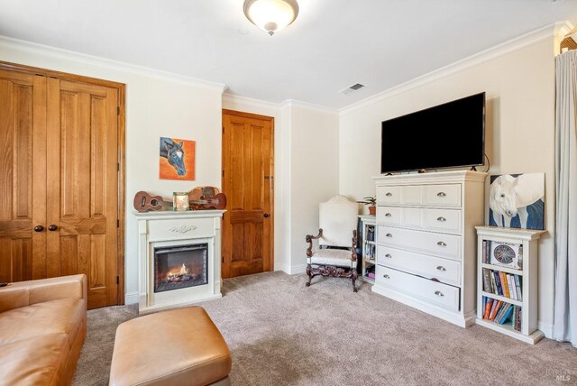 sitting room with visible vents, a lit fireplace, carpet flooring, and crown molding