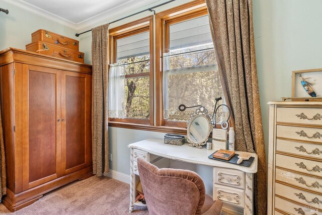 office space featuring crown molding, light colored carpet, baseboards, and built in desk