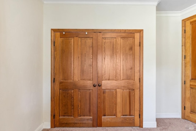 interior details with baseboards, ornamental molding, and carpet flooring