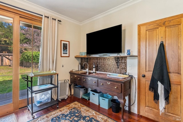 interior space with wood finished floors, crown molding, and radiator heating unit