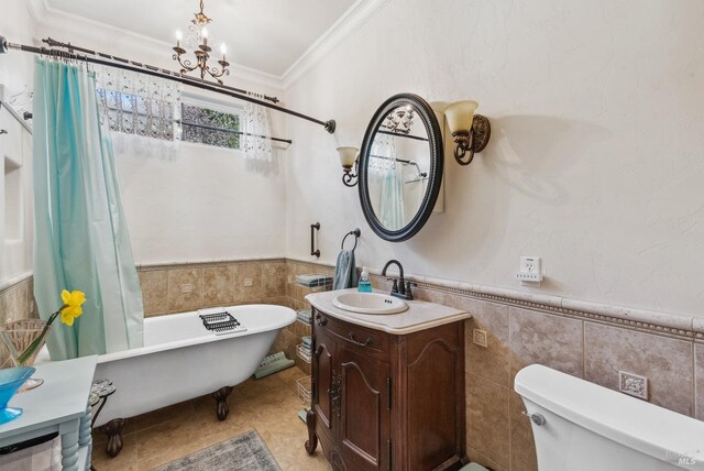 full bathroom with vanity, ornamental molding, a freestanding bath, tile walls, and toilet