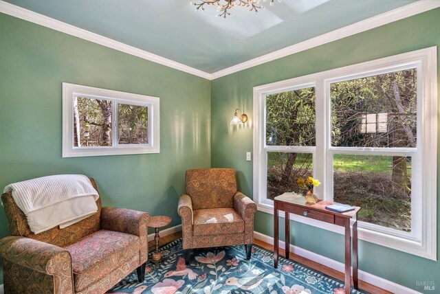 sitting room featuring a healthy amount of sunlight, crown molding, baseboards, and wood finished floors