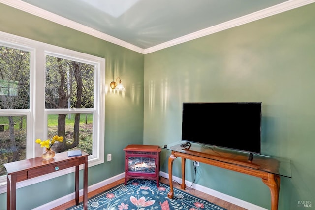 sitting room with ornamental molding, baseboards, and wood finished floors