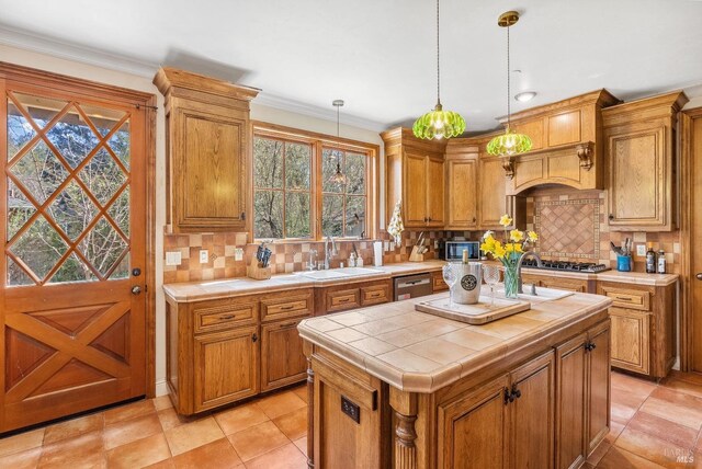 kitchen featuring decorative backsplash, tile counters, appliances with stainless steel finishes, and a sink