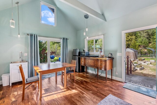 home office featuring a healthy amount of sunlight, high vaulted ceiling, baseboards, and wood finished floors