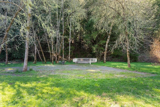 view of yard featuring a deck and a forest view