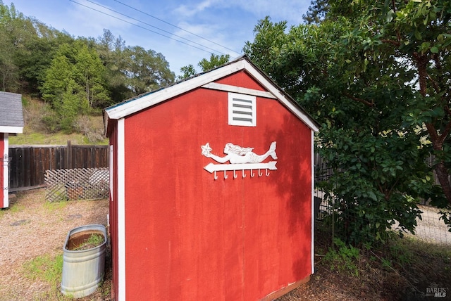 view of shed featuring fence