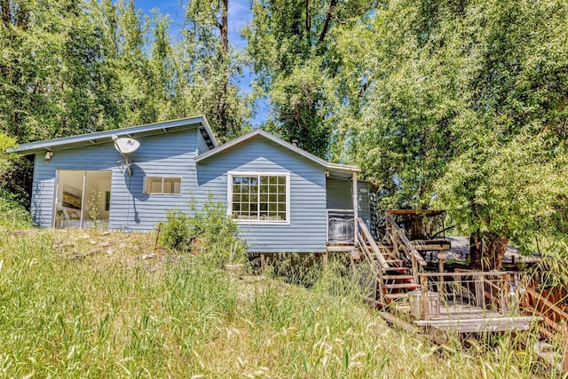 back of property featuring stairway and a wooden deck