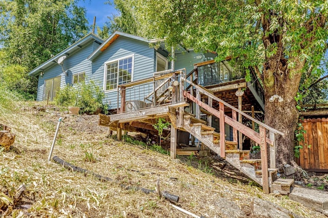 rear view of house featuring stairway and a wooden deck