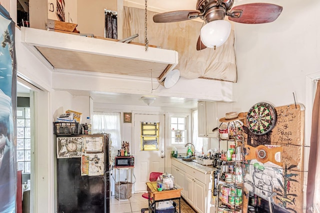 kitchen with plenty of natural light, freestanding refrigerator, ceiling fan, and light tile patterned floors