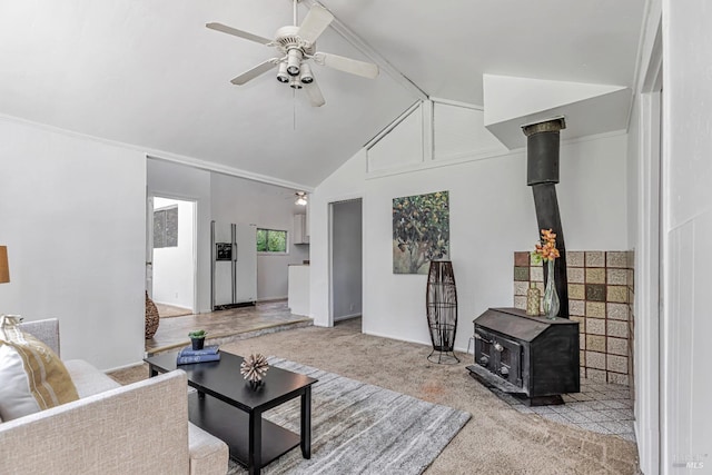 carpeted living area with high vaulted ceiling, ceiling fan, and a wood stove