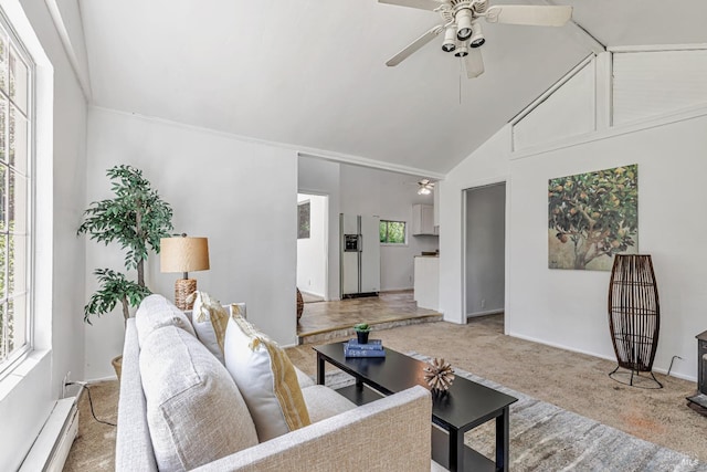 carpeted living area with plenty of natural light, a ceiling fan, and a baseboard heating unit