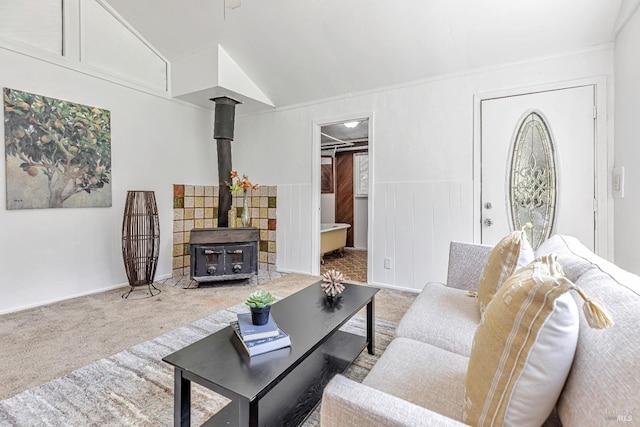 living area with carpet, a wood stove, and lofted ceiling