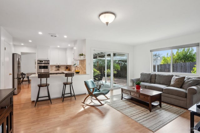 living area with a wealth of natural light, recessed lighting, and light wood-style flooring