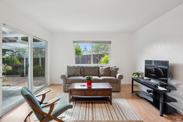 living area featuring baseboards and light wood-type flooring