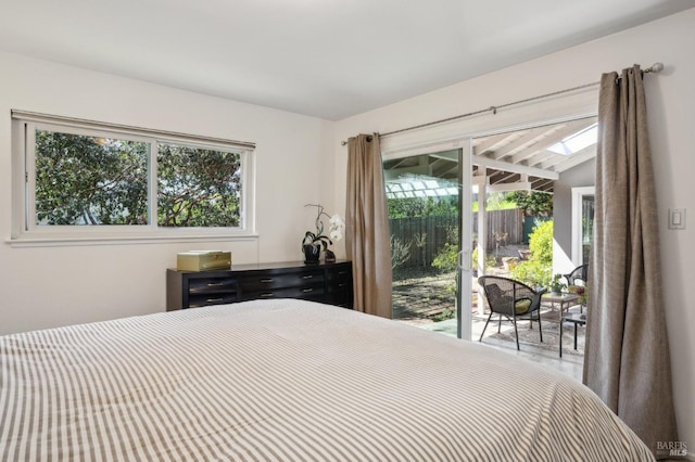 bedroom with access to exterior and a skylight