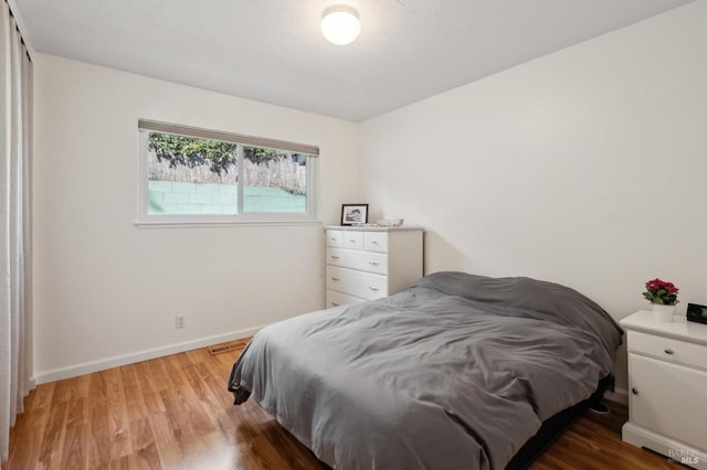 bedroom with light wood-style flooring and baseboards