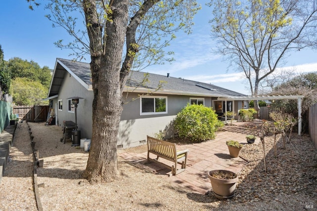 rear view of property with crawl space, a fenced backyard, stucco siding, and a patio area