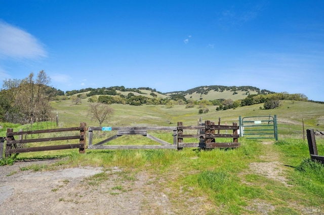 view of gate featuring a rural view, a mountain view, and fence