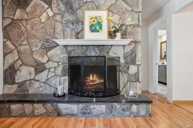 details with baseboards, wood finished floors, and a fireplace