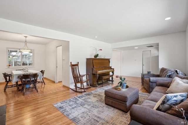 living room with recessed lighting, light wood-style flooring, and visible vents