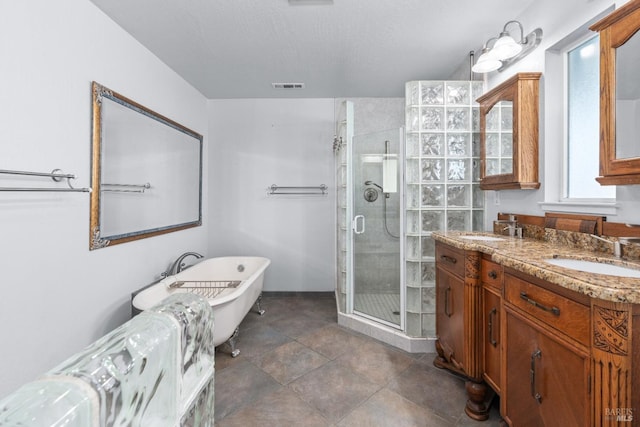 full bath with a sink, visible vents, a freestanding bath, and a shower stall