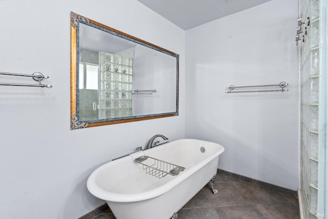 full bath with tile patterned floors, baseboards, and a freestanding bath