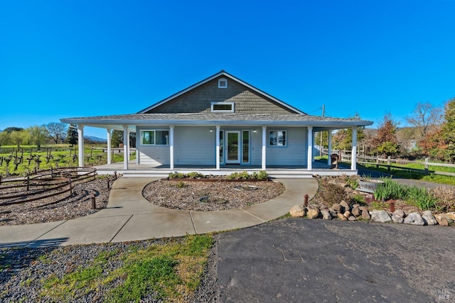 country-style home with a porch and fence