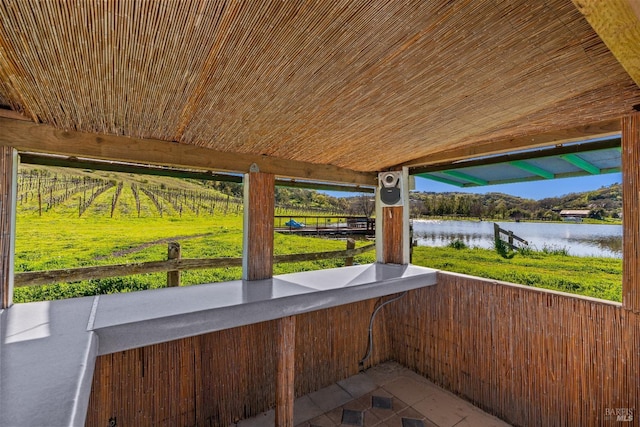 view of patio with a balcony and a water view