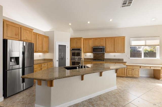 2550 Duncan St, Dixon, CA 95620 - kitchen with stainless steel appliances, a sink, dark stone countertops, a kitchen breakfast bar, and light tile patterned floors