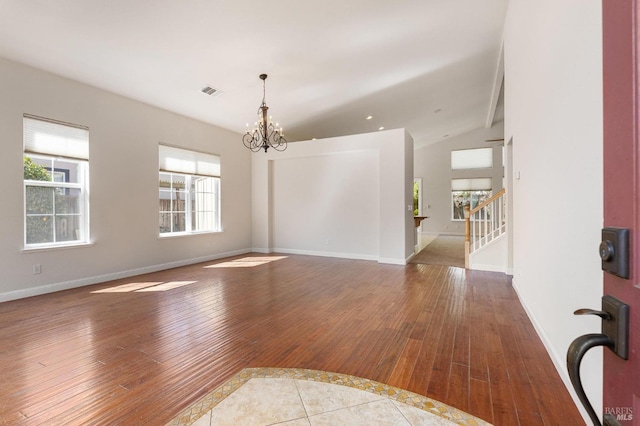 2550 Duncan St, Dixon, CA 95620 - empty room with hardwood / wood-style floors, a chandelier, vaulted ceiling, baseboards, and stairway