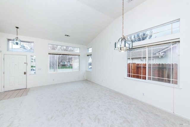 interior space featuring visible vents, a notable chandelier, carpet flooring, baseboards, and vaulted ceiling