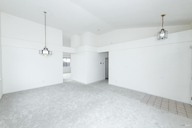 spare room featuring light carpet and high vaulted ceiling