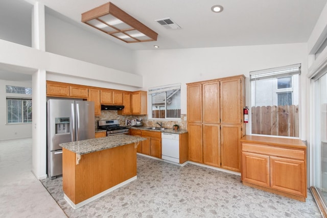 kitchen featuring visible vents, a sink, under cabinet range hood, appliances with stainless steel finishes, and a wealth of natural light