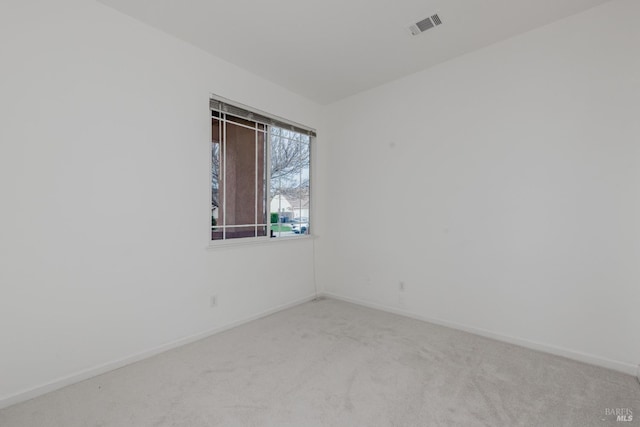 spare room featuring visible vents, baseboards, and carpet