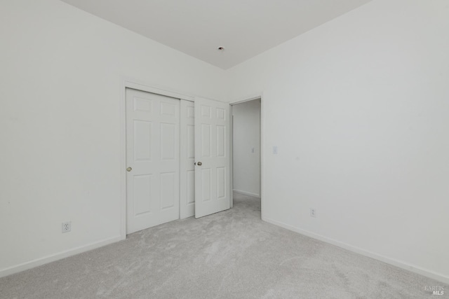 unfurnished bedroom with a closet, baseboards, and carpet floors