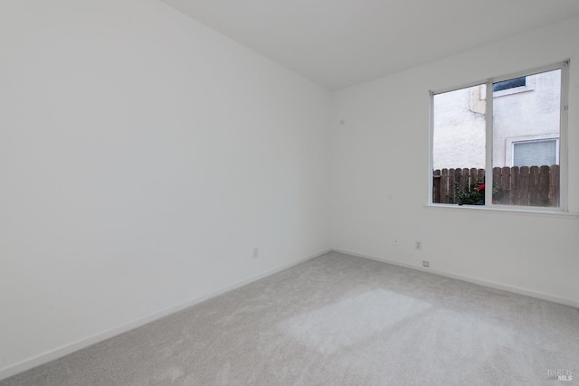 empty room with baseboards and light colored carpet