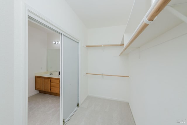 spacious closet with light carpet and a sink