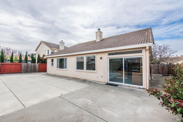 back of house with a patio, fence, a tile roof, and stucco siding