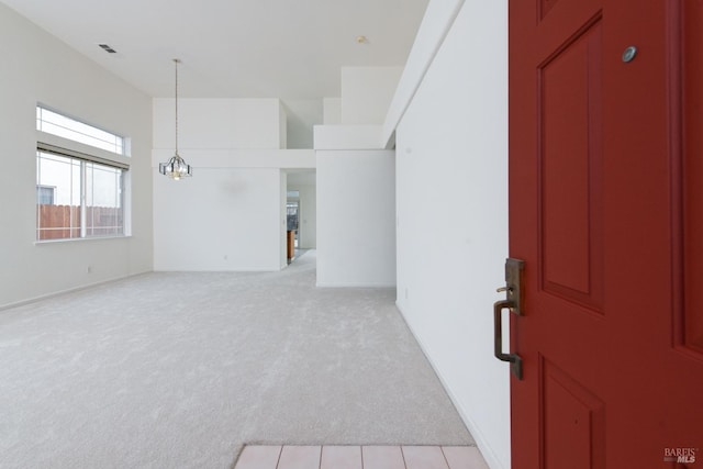 interior space with light carpet and an inviting chandelier