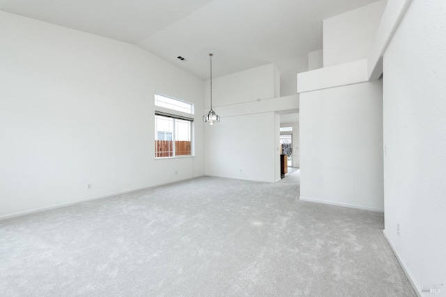 unfurnished room featuring visible vents, baseboards, high vaulted ceiling, light carpet, and a chandelier