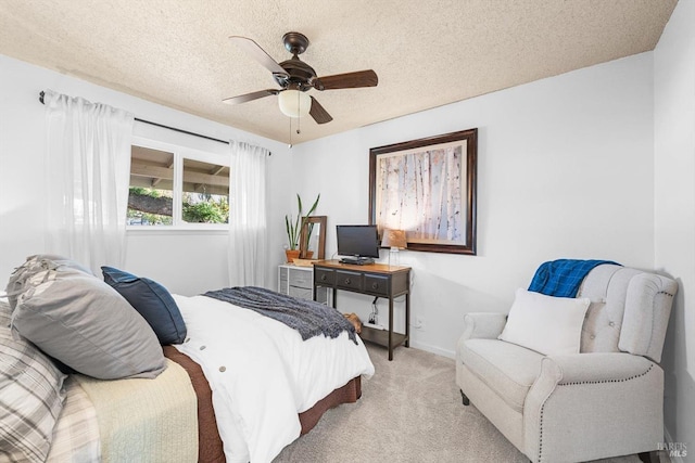 carpeted bedroom with a textured ceiling, baseboards, and a ceiling fan