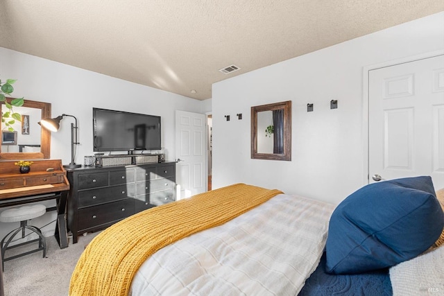 bedroom with visible vents, carpet, and a textured ceiling