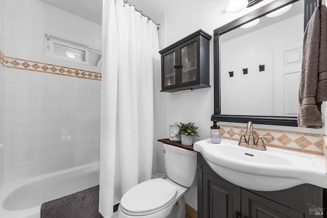 bathroom featuring vanity, decorative backsplash, toilet, and shower / bath combo