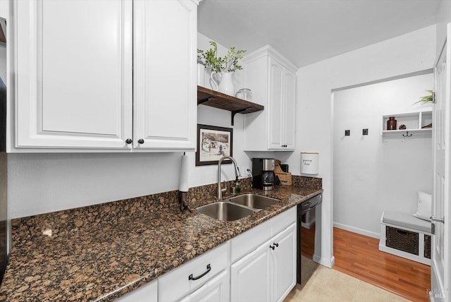 kitchen featuring a sink, black dishwasher, dark stone countertops, white cabinets, and open shelves