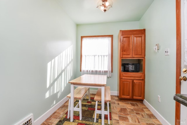 dining area with baseboards and stone finish floor