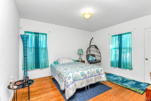 bedroom with baseboards and wood finished floors