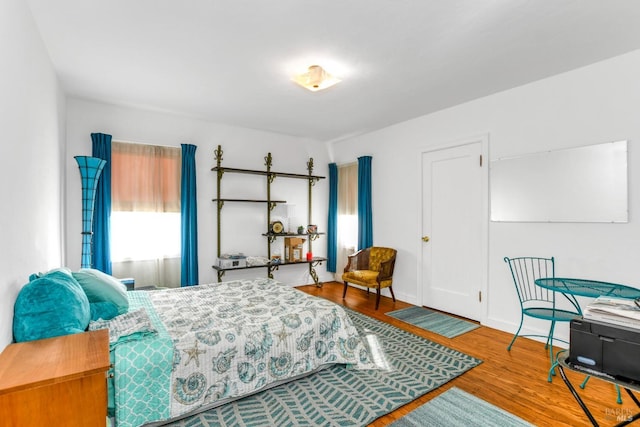 bedroom featuring baseboards and wood finished floors