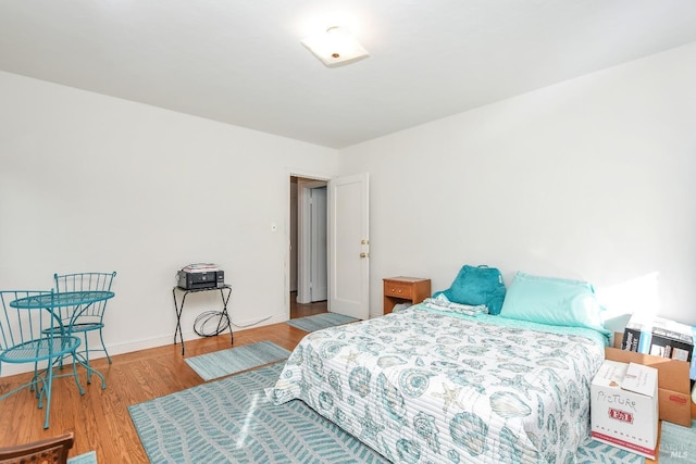 bedroom with baseboards and wood finished floors