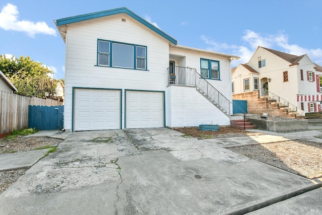 view of front facade featuring an attached garage, fence, and driveway